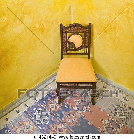 Stock Image - Empty chair in the corner of a room. Fotosearch