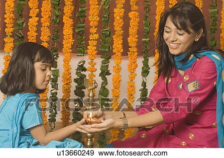 Girl lighting a oil lamp with her mother View Large Photo Image Stock Photo - Girl lighting a oil lamp with her mother. Fotosearch