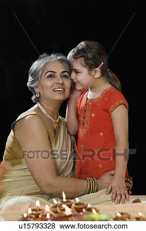Girl whispering into her grandmother's ear View Large Photo Image Stock Photo - Girl whispering into her grandmother's ear. Fotosearch