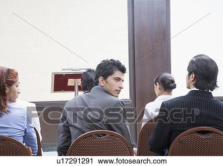 Group of business executives sitting on chairs in a meeting View Large Photo Image Stock Image - Group of business executives sitting on chairs in a meeting. Fotosearch