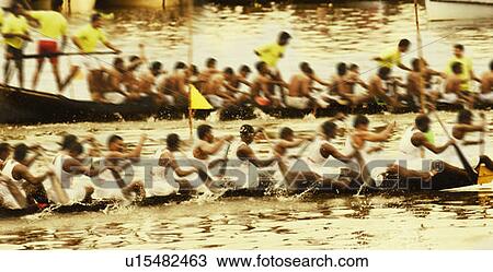 Stock Image - Group of people participating in a snake boat racing, Kerala, India. Fotosearch