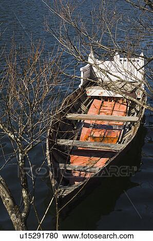Stock Image - High angle view of a boat tied up with a tree. Fotosearch