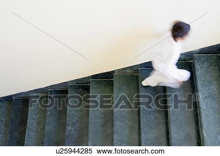 Stock Photography - High angle view of a boy running on a staircase. Fotosearch