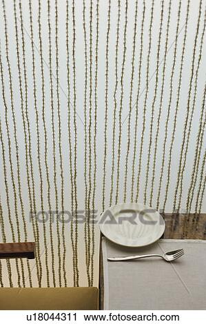 Stock Image - High angle view of a fork with a plate on the table. Fotosearch