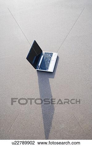 Stock Image - High angle view of a laptop on the beach. Fotosearch