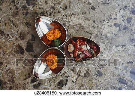 Stock Image - High angle view of a marigold flowers with spices in bowls. Fotosearch
