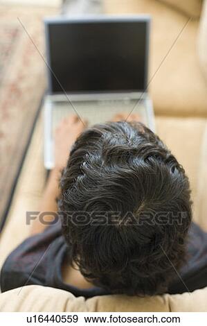 High angle view of a teenage boy working on a laptop View Large Photo Image Stock Photo - High angle view of a teenage boy working on a laptop. Fotosearch