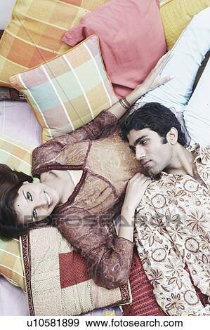 Stock Photo - High angle view of a young man lying on a woman's lap. Fotosearch