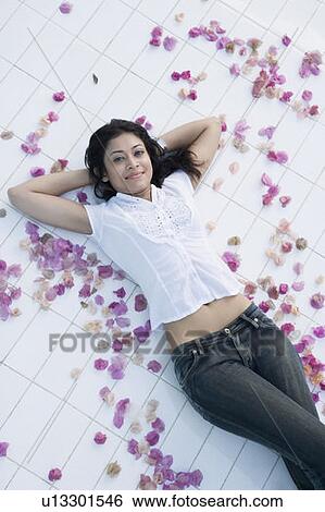 Stock Photograph - High angle view of a young woman lying on her back on the floor. Fotosearch