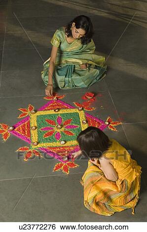 High angle view of a young woman making rangoli with her daughter View Large Photo Image Stock Photograph - High angle view of a young woman making rangoli with her daughter. Fotosearch