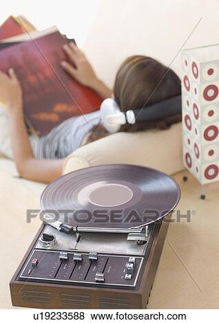 Stock Photo - High angle view of a young woman wearing headphones and listening to music. Fotosearch