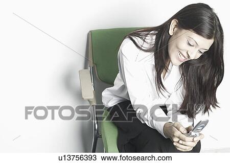 High angle view of a young woman using a mobile phone View Large Photo Image Stock Image - High angle view of a young woman using a mobile phone. Fotosearch