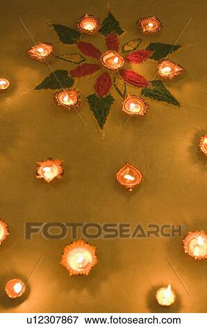 Stock Photo - High angle view of oil lamps and a rangoli. Fotosearch