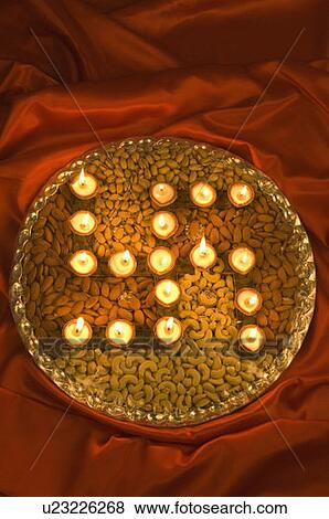High angle view of oil lamps forming swastika on a plate of dry fruits View Large Photo Image Stock Photo - High angle view of oil lamps forming swastika on a plate of dry fruits. Fotosearch