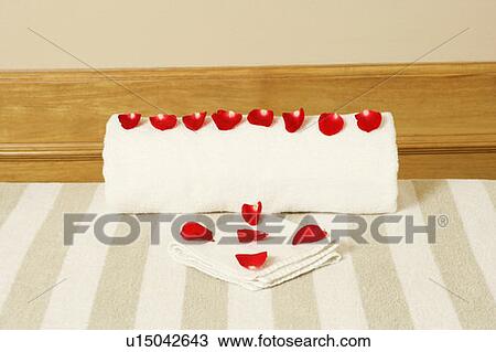 Stock Image - High angle view of rose petals on towels. Fotosearch