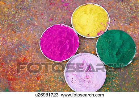 Stock Image - High angle view of various powder paints in plates on Holi festival. Fotosearch