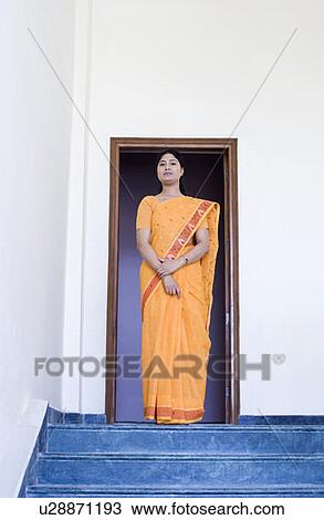 Low angle view of a mid adult woman standing on a doorway View Large Photo Image Stock Image - Low angle view of a mid adult woman standing on a doorway. Fotosearch