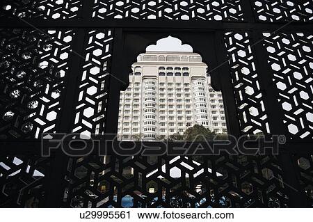 Stock Image - Low angle view of a multi-storied building through a window. Fotosearch