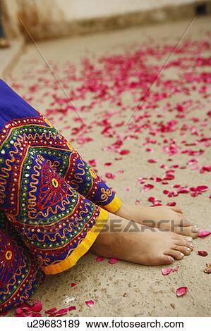 Stock Photo - Low section view of a woman with rose petals scattered around her. Fotosearch