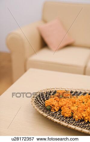 Stock Photo - Marigolds in a wicker plate on the table. Fotosearch