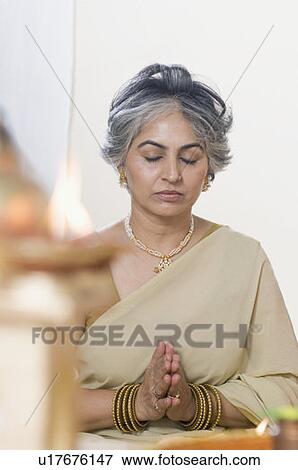 Stock Photo - Mature woman performing Lakshmi pujan. Fotosearch