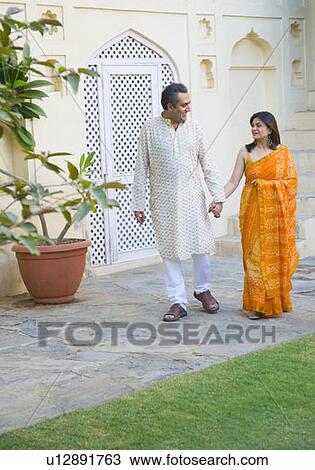 Mid adult couple holding hands of each other and walking View Large Photo Image Stock Image - Mid adult couple holding hands of each other and walking. Fotosearch