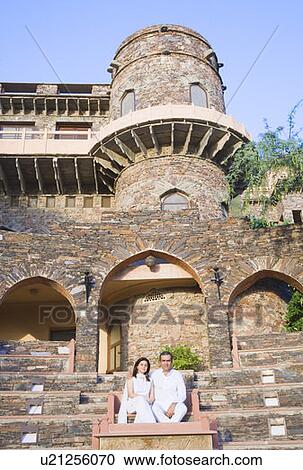 Stock Image - Mid adult couple sitting on steps. Fotosearch