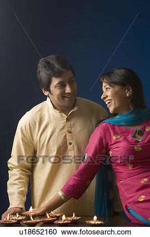 Mid adult man and a young woman smiling near oil lamps View Large Photo Image Stock Image - Mid adult man and a young woman smiling near oil lamps. Fotosearch