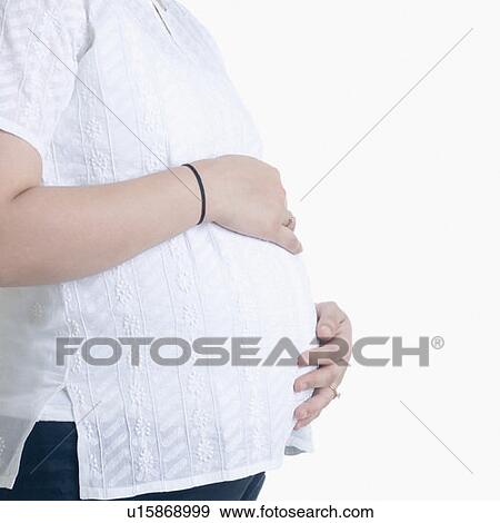 Mid section view of a pregnant woman View Large Photo Image Stock Photo - Mid section view of a pregnant woman. Fotosearch