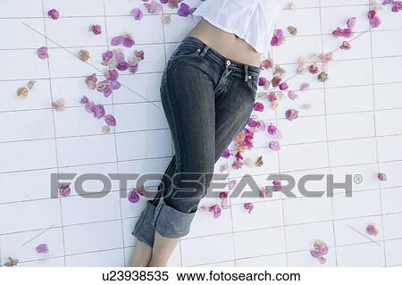 Mid section view of a young woman lying on the floor View Large Photo Image Stock Photography - Mid section view of a young woman lying on the floor. Fotosearch