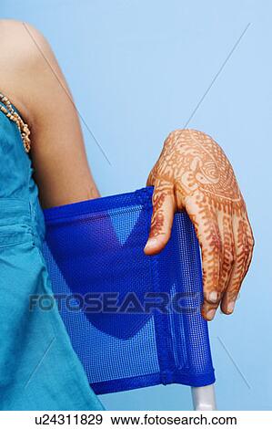 Stock Photo - Mid section view of a young woman sitting in an armchair. Fotosearch