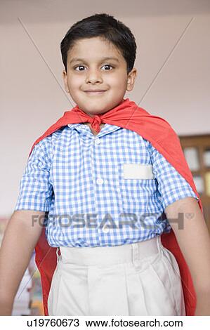 Stock Image - Portrait of a boy imitating to be a superhero and smiling. Fotosearch