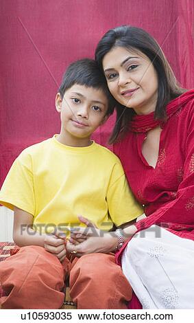 Stock Photography - Portrait of a boy with his mother sitting on the bed. Fotosearch