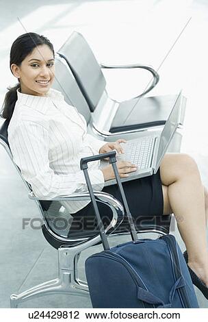 Stock Image - Portrait of a businesswoman sitting and using a laptop. Fotosearch