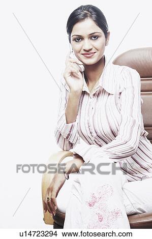Portrait of a Businesswoman sitting on a chair talking on a mobile phone View Large Photo Image Picture - Portrait of a Businesswoman sitting on a chair talking on a mobile phone. Fotosearch