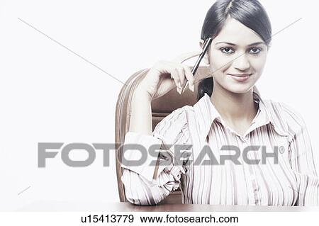Portrait of a businesswoman sitting on a chair holding a pen View Large Photo Image Stock Photo - Portrait of a businesswoman sitting on a chair holding a pen. Fotosearch