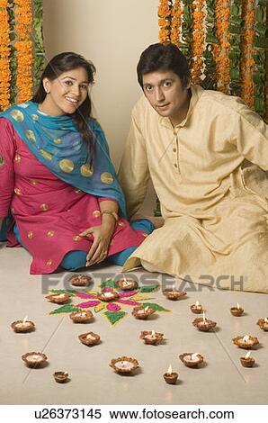 Stock Photography - Portrait of a couple kneeling behind oil lamps. Fotosearch