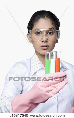 Stock Image - Portrait of a female lab technician holding test tubes. Fotosearch