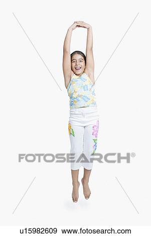 Stock Photo - Portrait of a girl jumping and smiling with her arms raised. Fotosearch