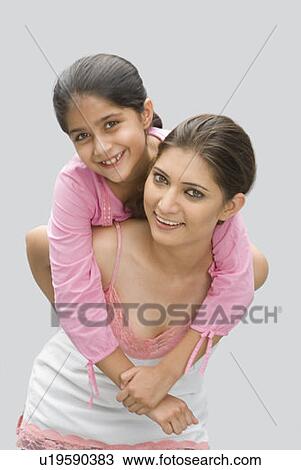 Portrait of a girl riding piggyback on her mother's back and smiling View Large Photo Image Stock Image - Portrait of a girl riding piggyback on her mother's back and smiling. Fotosearch