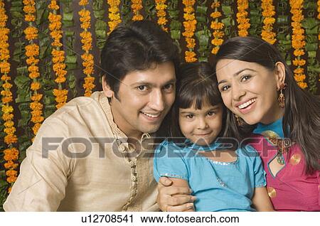 Portrait of a girl smiling between her parents View Large Photo Image Stock Image - Portrait of a girl smiling between her parents. Fotosearch