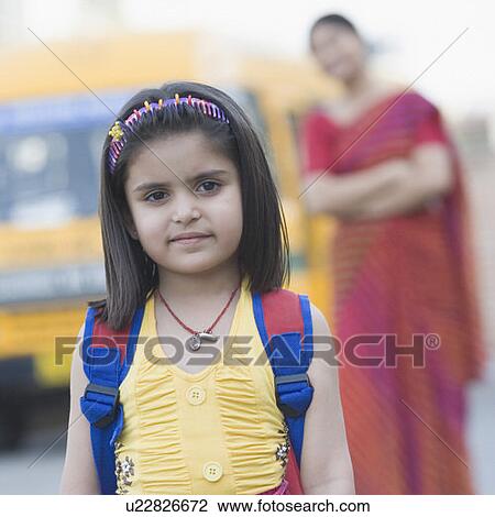 Portrait of a girl standing on the road with her teacher standing in the background View Large Photo Image Stock Image - Portrait of a girl standing on the road with her teacher standing in the background. Fotosearch