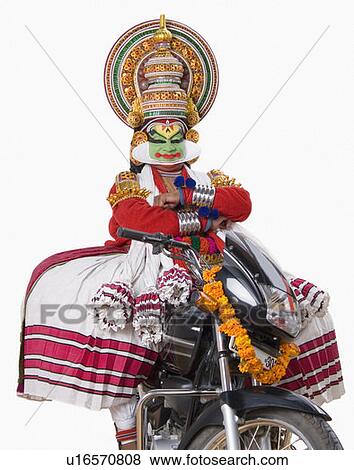 Stock Photo - Portrait of a Kathakali dance performer sitting on a motorcycle. Fotosearch