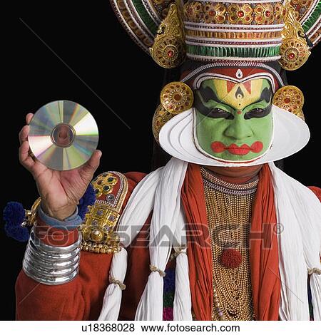 Stock Photo - Portrait of a Kathakali dance performer holding a CD. Fotosearch