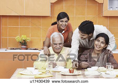 Portrait of a mature couple and their two children at the dinning table View Large Photo Image Stock Photo - Portrait of a mature couple and their two children at the dinning table. Fotosearch