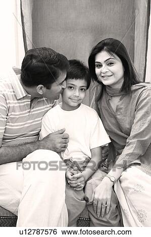 Portrait of a mid adult couple sitting with their son View Large Photo Image Stock Photograph - Portrait of a mid adult couple sitting with their son. Fotosearch