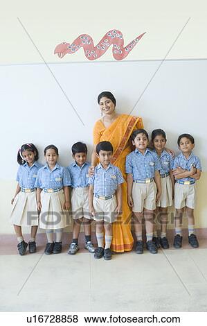 Stock Photo - Portrait of a teacher standing with schoolchildren and smiling. Fotosearch
