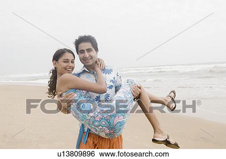 Portrait of a young man carrying a young woman View Large Photo Image Stock Photograph - Portrait of a young man carrying a young woman. Fotosearch