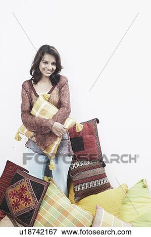 Stock Photo - Portrait of a young woman holding a cushion. Fotosearch