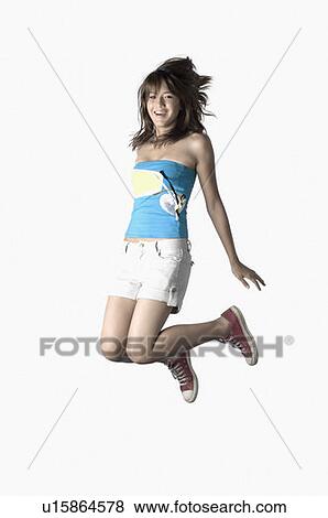 Portrait of a young woman jumping and smiling View Large Photo Image Stock Photo - Portrait of a young woman jumping and smiling. Fotosearch